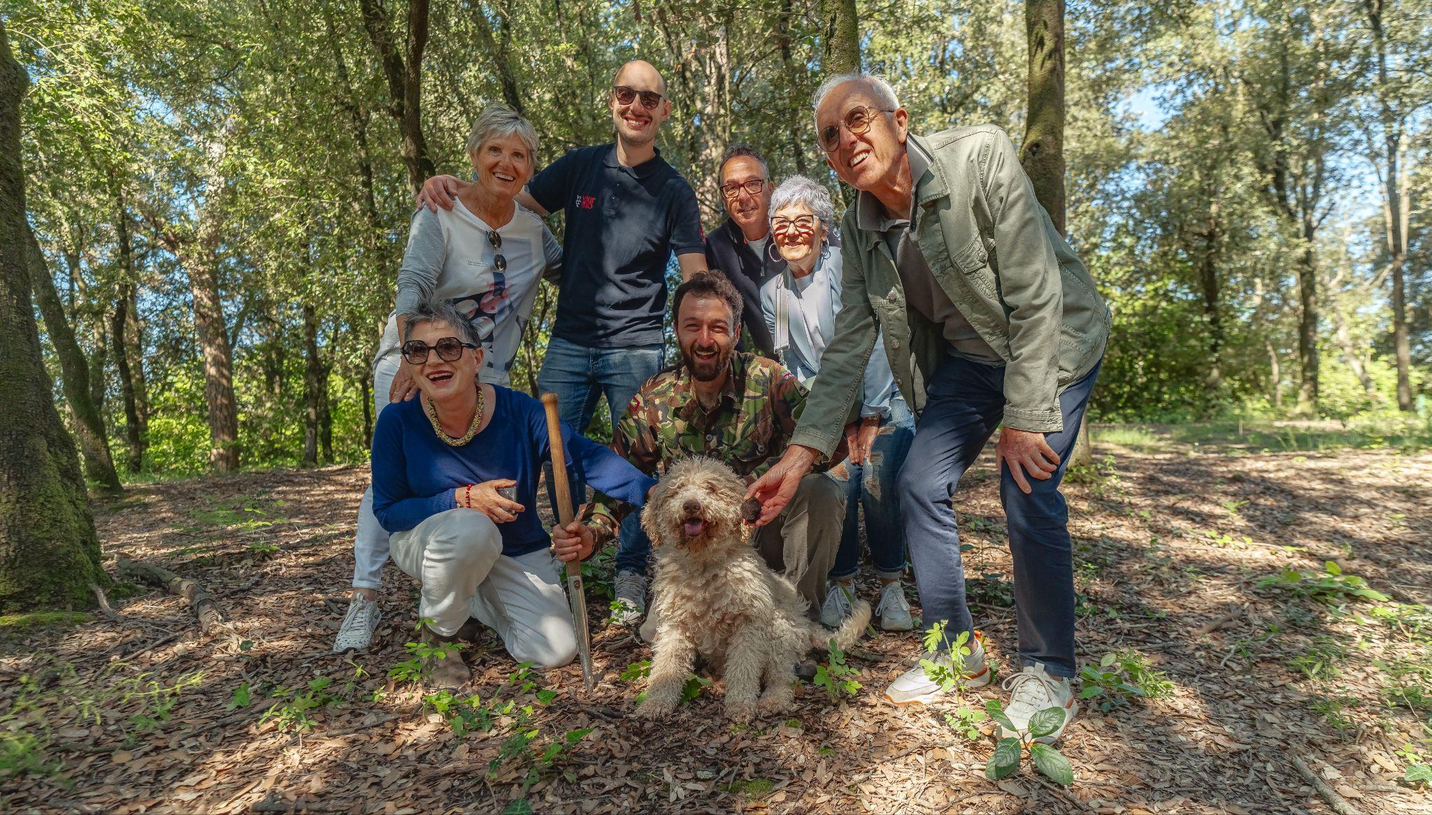 A truffle hunter and his dog with a small group in the woods of Tuscany's truffle country