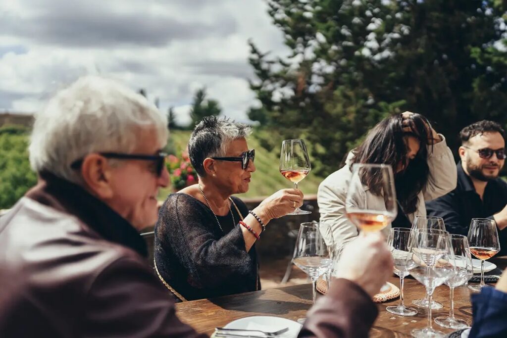 Guests tasting a glass of Tuscan white wine outdoors on a Your Vino tasting terrace