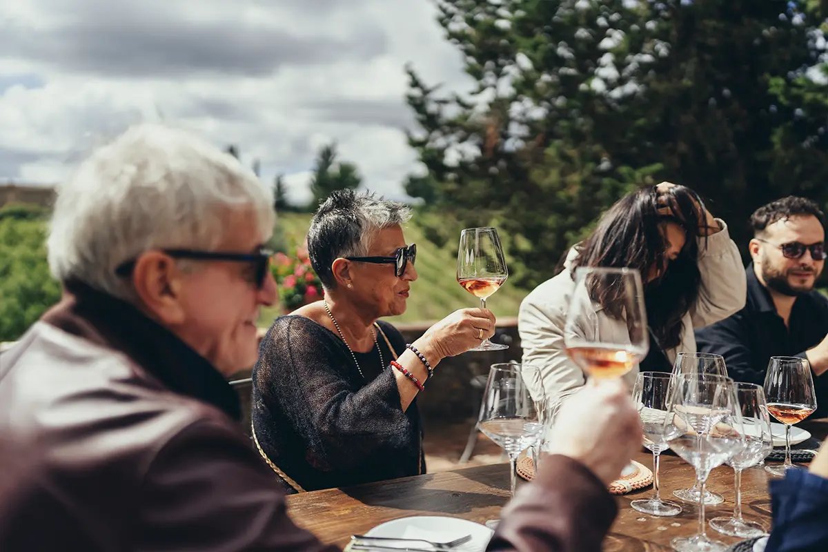Guests tasting a glass of Tuscan white wine outdoors on a Your Vino tasting terrace
