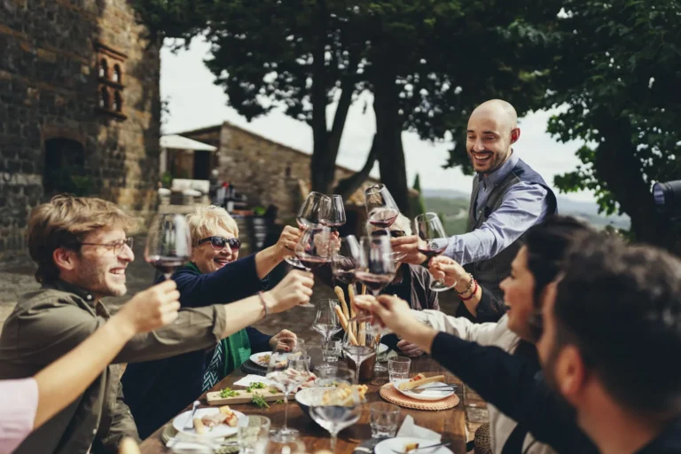Guests toasting with red wine at lunch in a Chianti winery