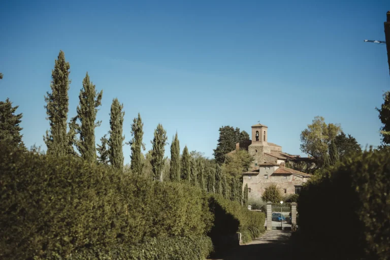 Cypress trees and a stone village in the Tuscan countryside