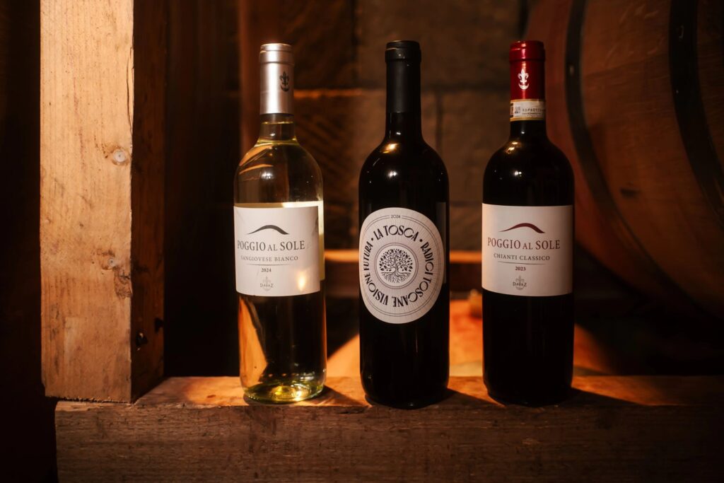 Three bottles of Tuscan wine, a Sangiovese Bianco, La Tosca and a Chianti Classico, standing in a wooden crate